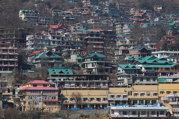 Colorful Rooftops Over Shimla Slopes Panoramic view of hillside structures with green, red, and yellow rooftops in Shimla, showing the charm of a mountain city.