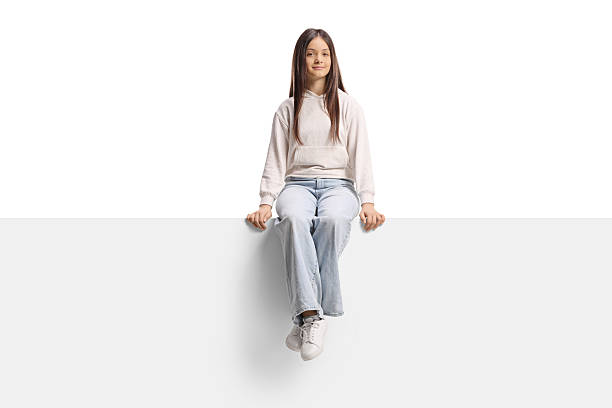 istock Teenage girl sitting on a blank panel 2250980355