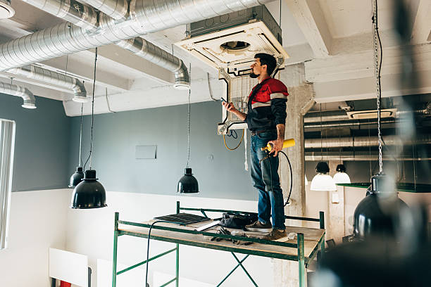 istock Worker installs HVAC unit in modern building interior during daytime renovation project 2250982638
