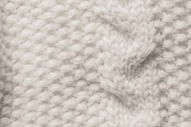 istock Close-up of a soft, textured white knitted fabric with a cable pattern 2250983078