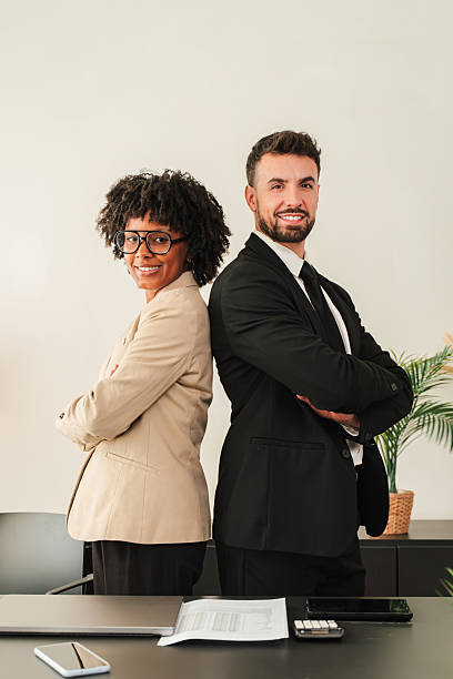 istock Confident business partners standing back to back, showcasing teamwork and professionalism in suits 2250984394