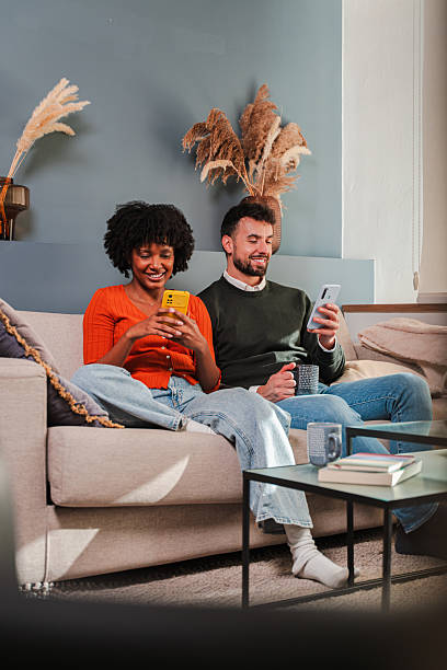 istock Couple enjoying quality time together while using their smartphones on a cozy sofa at home 2250986105