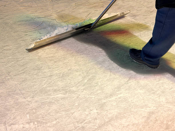 Three curling stones in the target house, with the sweepers standing by