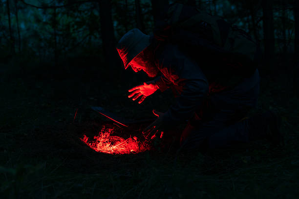 istock A bearded man is sitting by the open ground, light is coming from a hole in the ground 2250992989