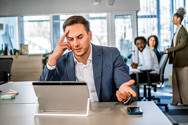 istock Stressed businessman working on tablet in modern office 2250993929
