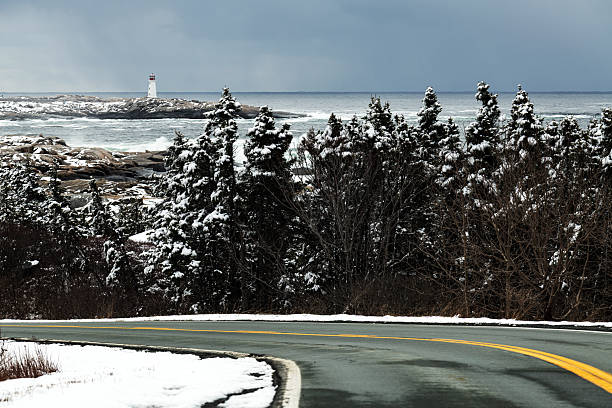 Peggy's Cove Lighthouse in the distance after a light snowfall.