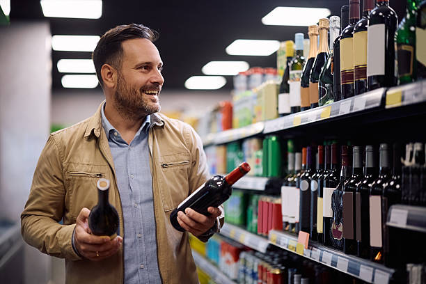 istock Happy man buying wine at the store. 2251002343