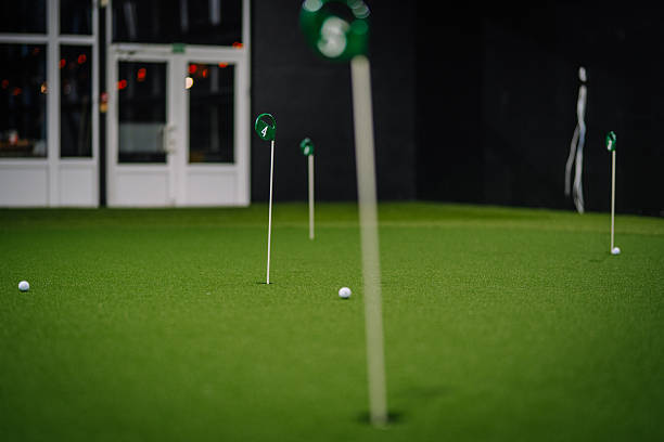 istock Indoor golf putting area with artificial turf, featuring multiple holes and golf balls, creating a vibrant and engaging sports environment 2251008106
