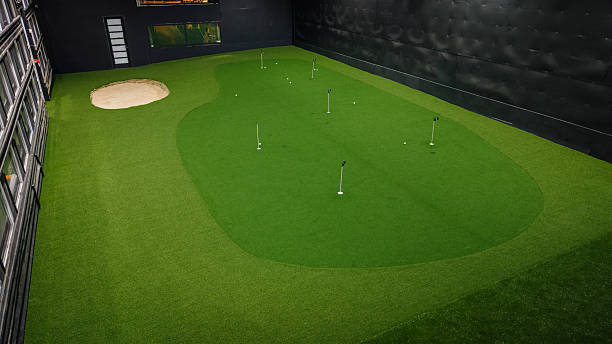 istock Indoor golf putting green with artificial turf, sand trap, and multiple holes, showcasing a modern recreational space for golf enthusiasts 2251010903