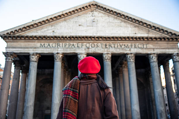 Contemplative young Latin woman tourist  looking away while standing near Tempio di Adriano in Rome, Italy