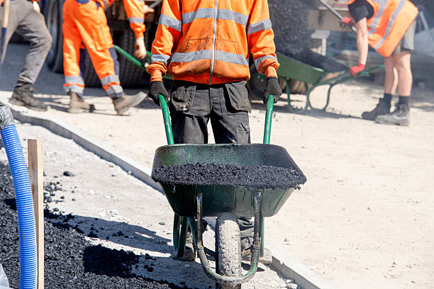 istock Construction workers in high-visibility gear are applyin gfresh hot asphalt to roadway surface 2251016747