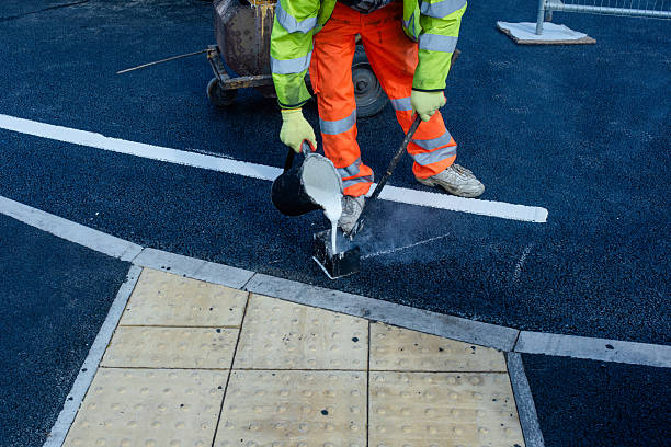 istock Road construction activity with roadworker applying hot melted white paint for traffic lines demarcation on new road surface 2251017467
