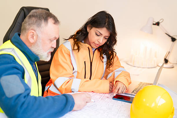 istock Construction project manager and architect collaborating to discuss blueprints drawings and plans at workspace office 2251017561