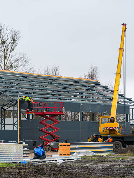 istock Workers installing sandwich panels on steel structure using crane and lift during industrial building construction 2251020064