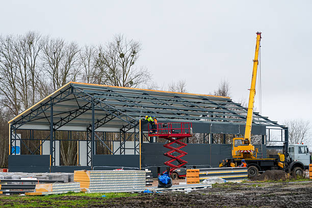 istock Construction workers install wall panels on a steel industrial building frame using lift and crane 2251020069
