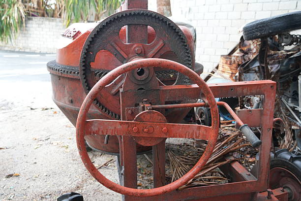 istock Old red cement mixer machine with rusty wheel and gear 2251020217