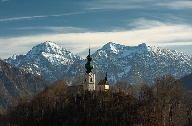 Church in the town of Ruhpolding, Bavaria, Germany. Snowcapped Mount Sonntagshorn in Background. Sunny spring day.