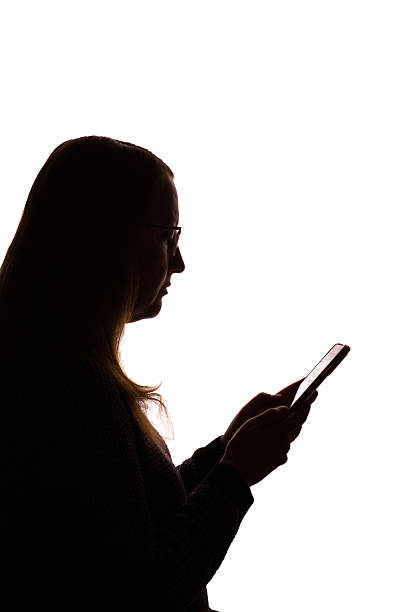 istock Silhouette of young woman using smartphone on white background 2251023213