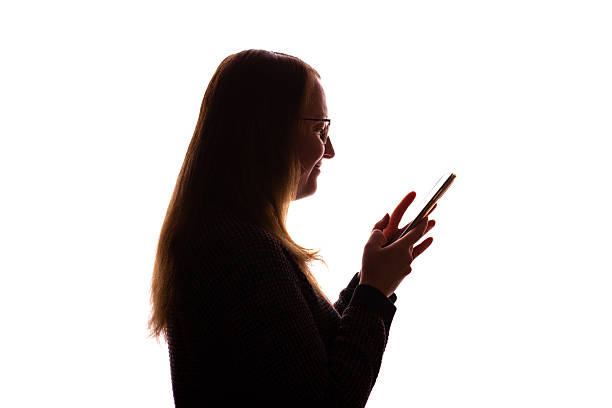istock Silhouette of young woman using smartphone on white background 2251023242