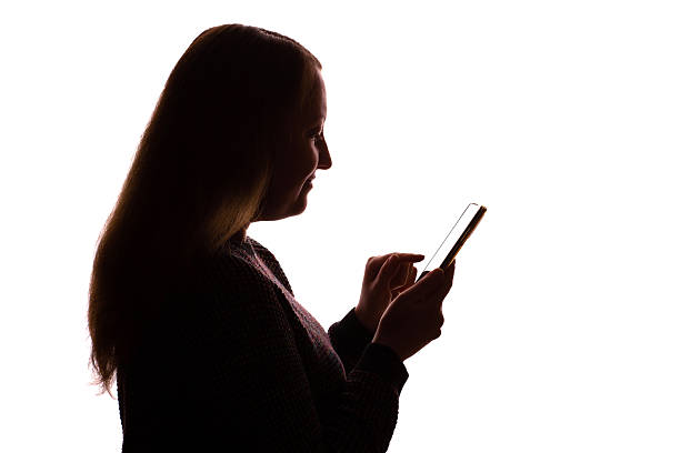 istock Silhouette of young woman using smartphone on white background 2251023256