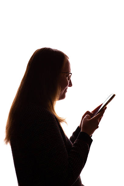 istock Silhouette of young woman using smartphone on white background 2251023295