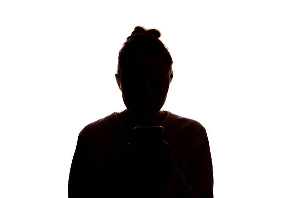 istock Silhouette young woman with hair up using smartphone, white background 2251023390