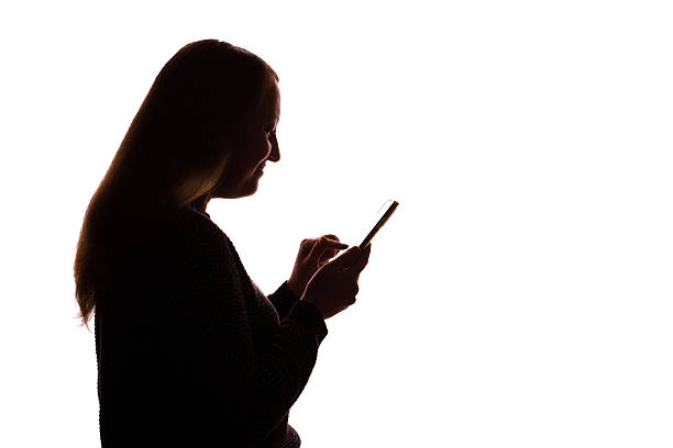 istock Silhouette of young woman using smartphone on white background 2251023405