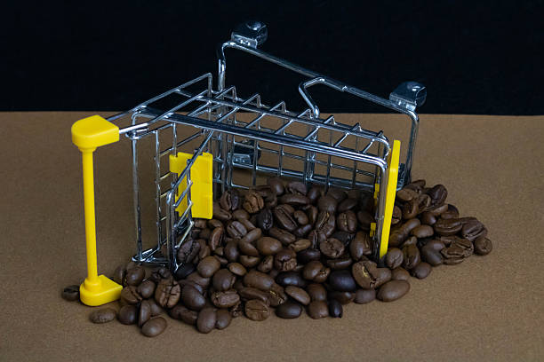 A small shopping cart fell, scattering coffee beans on a brown background