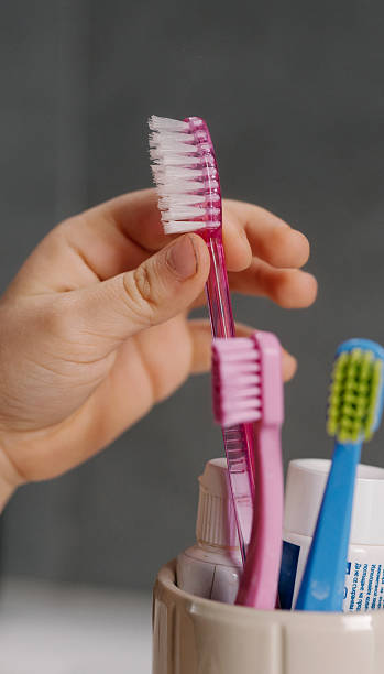 istock Bright Bathroom Preparation, Homeowner Arranges Toothbrush From Ceramic Holder In Peaceful Space 2251026478