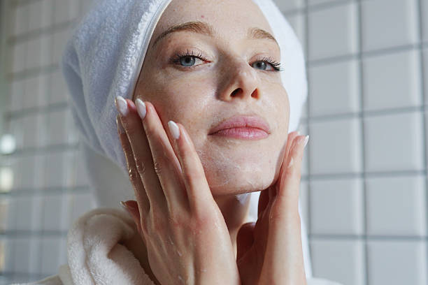 istock Woman In Bathrobe Gently Applying Moisturizing Mask In Peaceful Bathroom Setting For Glowing Skin 2251027168