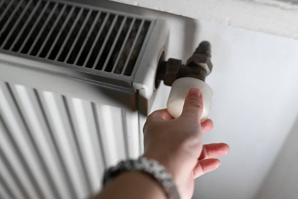 istock A hand adjusting a radiator valve in a home interior. The image represents heating control, energy saving, and household maintenance. 2251030250
