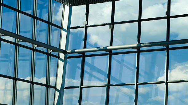 istock Large window with blue sky and clouds. sky is clear and bright, and the clouds are scattered throughout  sky. window is made of glass and is located in a building. 2251030741