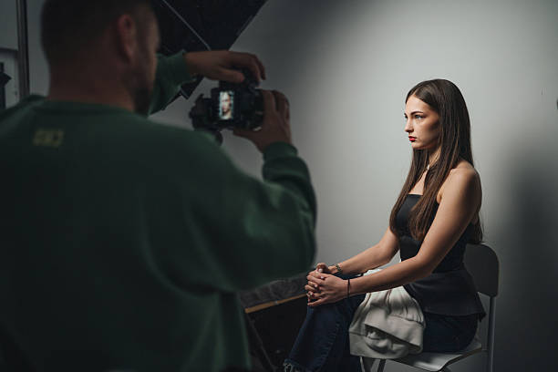 Studio Portrait Model Posing For Photographer, Moody LowKey Lighting, Neutral Backdrop, Seated On Stool,