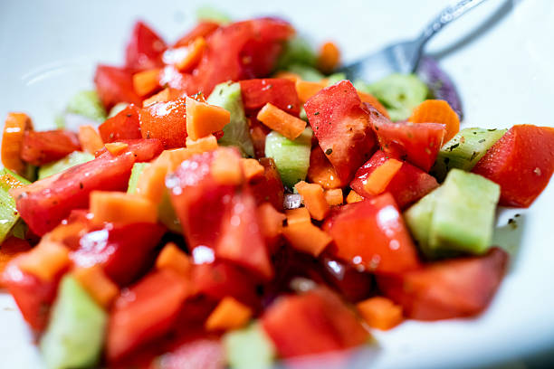 Close up shot of fresh sallad with vegetables placed in a white deep plate