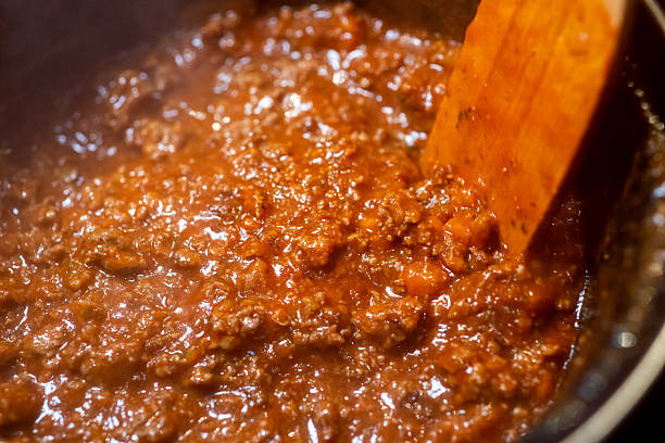 Close up shot of bolognese sauce being prepared at home and pasta