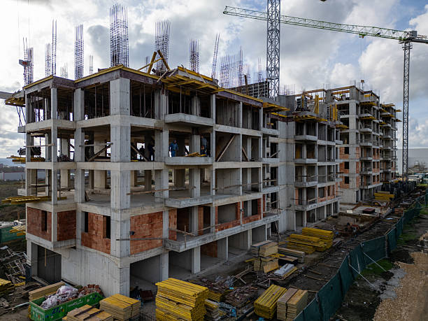 istock Construction site of a multi-story residential building covered in scaffolding, workers finishing exterior walls, captured in a detailed urban development scene 2251034418