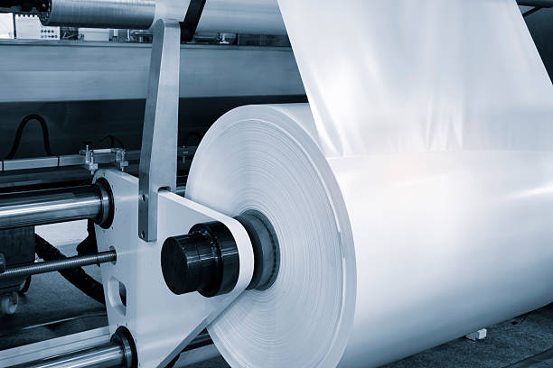 istock Automatic polyethylene plastic bag production machine with lighting effect. Close-up of the roller of the plastic bag production machine in the light blue scene. product packaging concept 2251036047