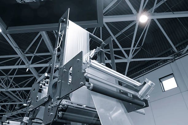 Automatic polyethylene plastic bag production machine with lighting effect. Close-up of the roller of the plastic bag production machine in the light blue scene. product packaging concept