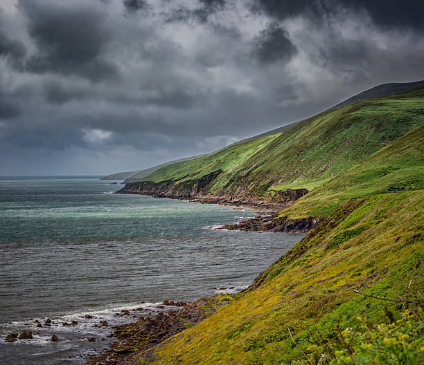 A significant body of water rests atop a green hillside in Ireland.