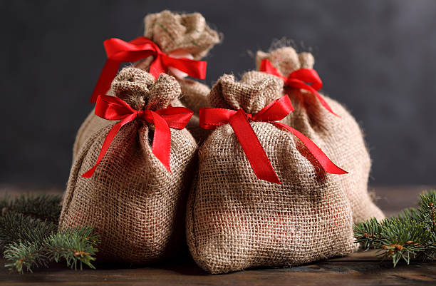 Four Christmas gift bags with pine tree branch