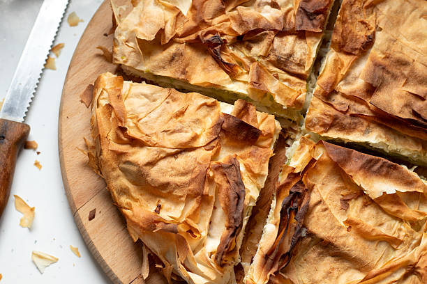 Sliced burek pie on wooden cutting board