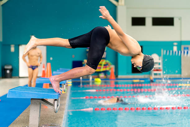 istock Young boy diving from starting block in swimming pool 2251058503