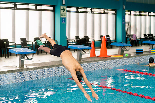 istock Boy diving into swimming pool during swimming lesson 2251058504