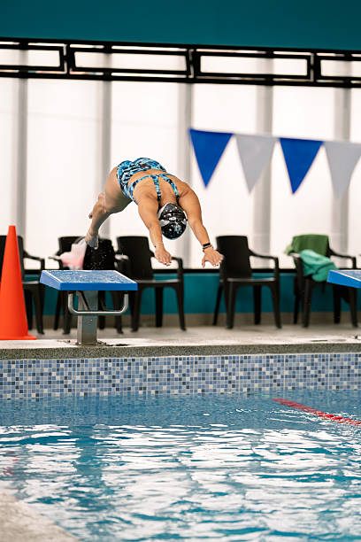 istock Swimmer diving from starting block into swimming pool 2251058560