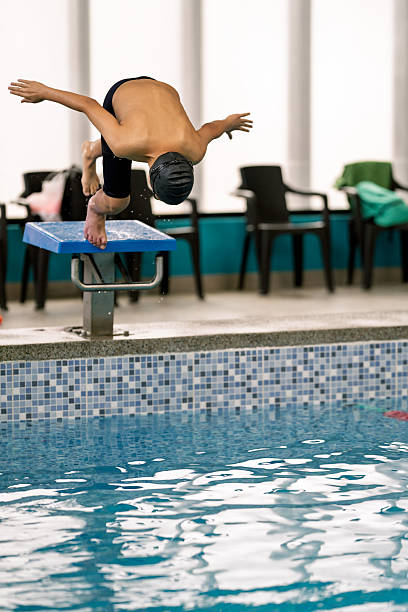 istock Boy diving into swimming pool during swimming lesson 2251058566