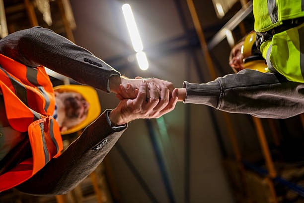 istock Close-Up Handshake Between Construction Professionals in Safety Gear and Vests 2251059768