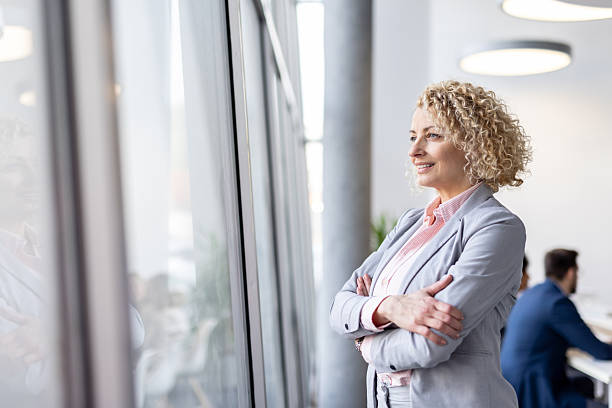 istock Businesswoman gazing out window with a thoughtful expression 2251059790