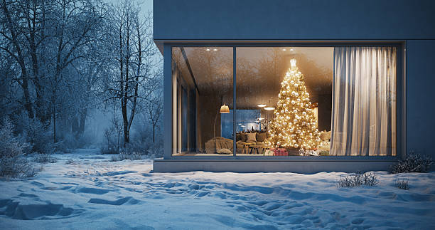 istock Warm Christmas Tree Glowing Inside Modern House In Snowy Winter Forest 2251059815