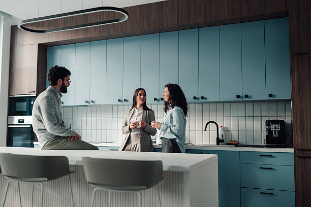 istock Colleagues taking coffee break, talking and socializing in modern office kitchen 2251060057