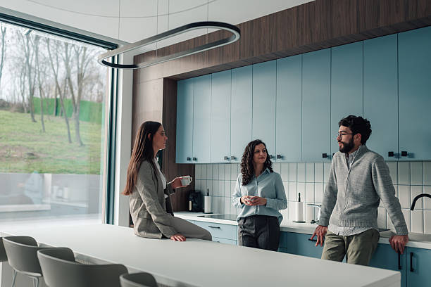 istock Colleagues having coffee break and talking in office kitchen 2251060070
